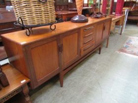 A mid-20th century teak sideboard having four drawers flanked by two sets of cupboard doors