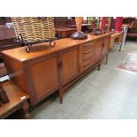 A mid-20th century teak sideboard having four drawers flanked by two sets of cupboard doors