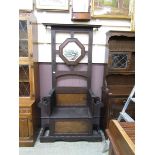 An early 20th century oak hall stand having a hexagonal framed mirror with a seated lift up lid