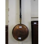 A brass and copper bed warming pan