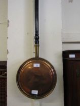 A brass and copper bed warming pan