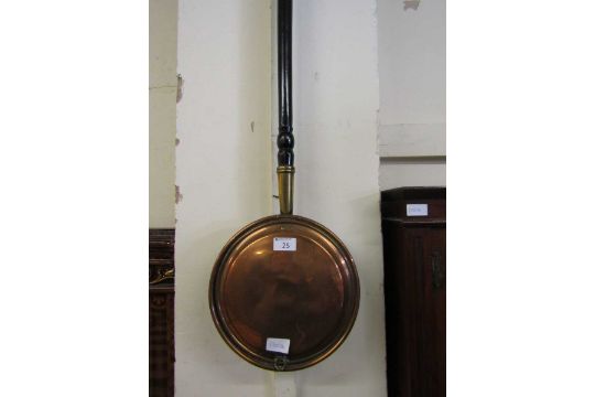 A brass and copper bed warming pan