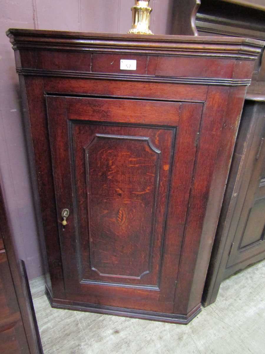 A Georgian oak wall mounted corner cupboard