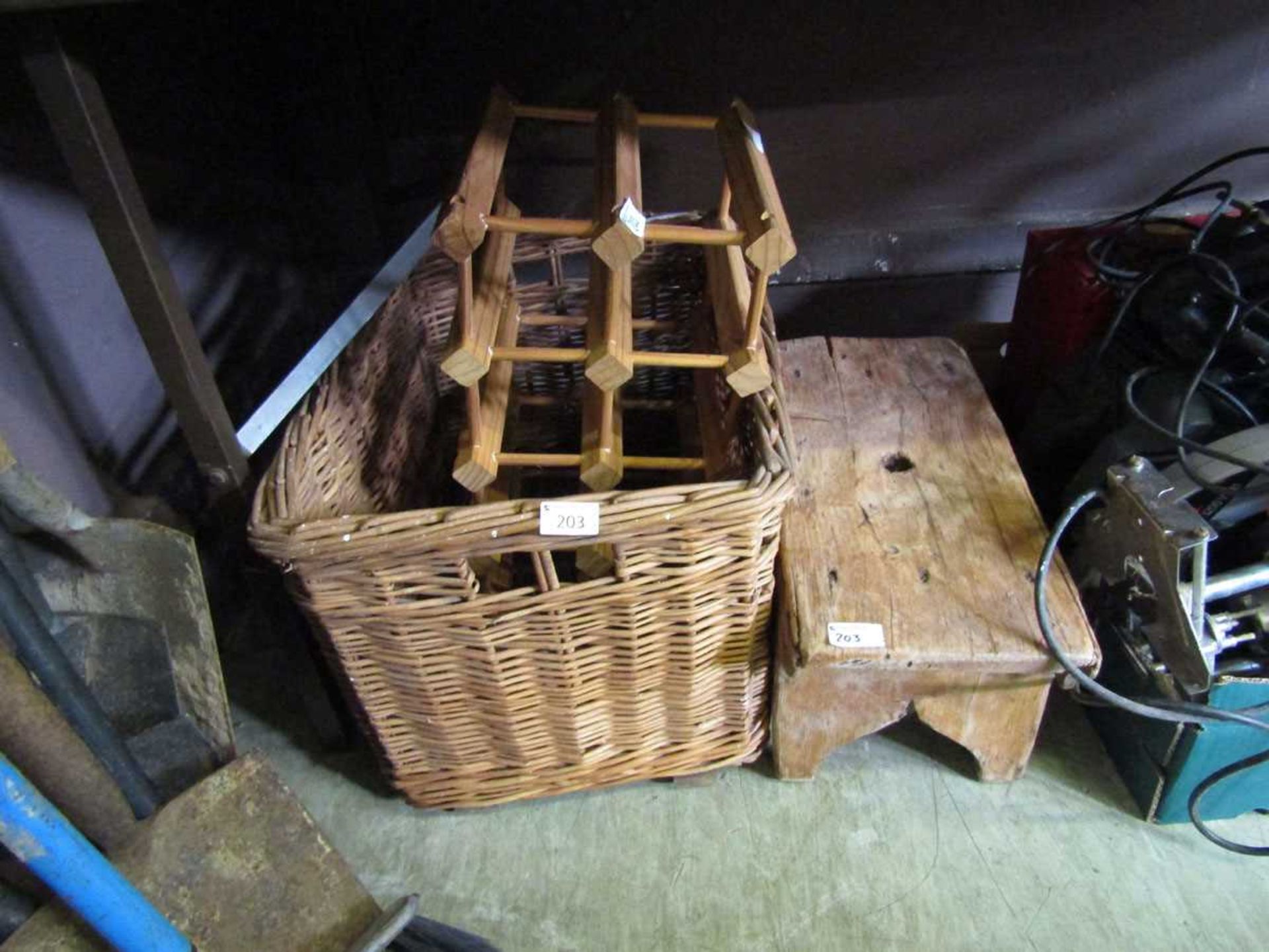 A wicker basket together with a pine wine rack and small wooden stool