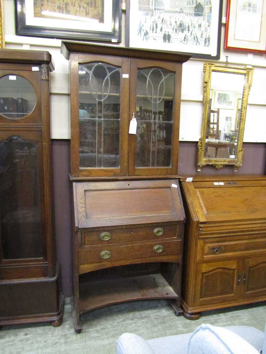 An early 20th century bureau bookcase having a pair of leaded glazed doors to top, the base having