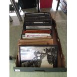 A tray containing an assortment of framed and unframed prints, street scenes, etc