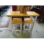 A high pine topped table with a pair of matching stools with cream painted supports