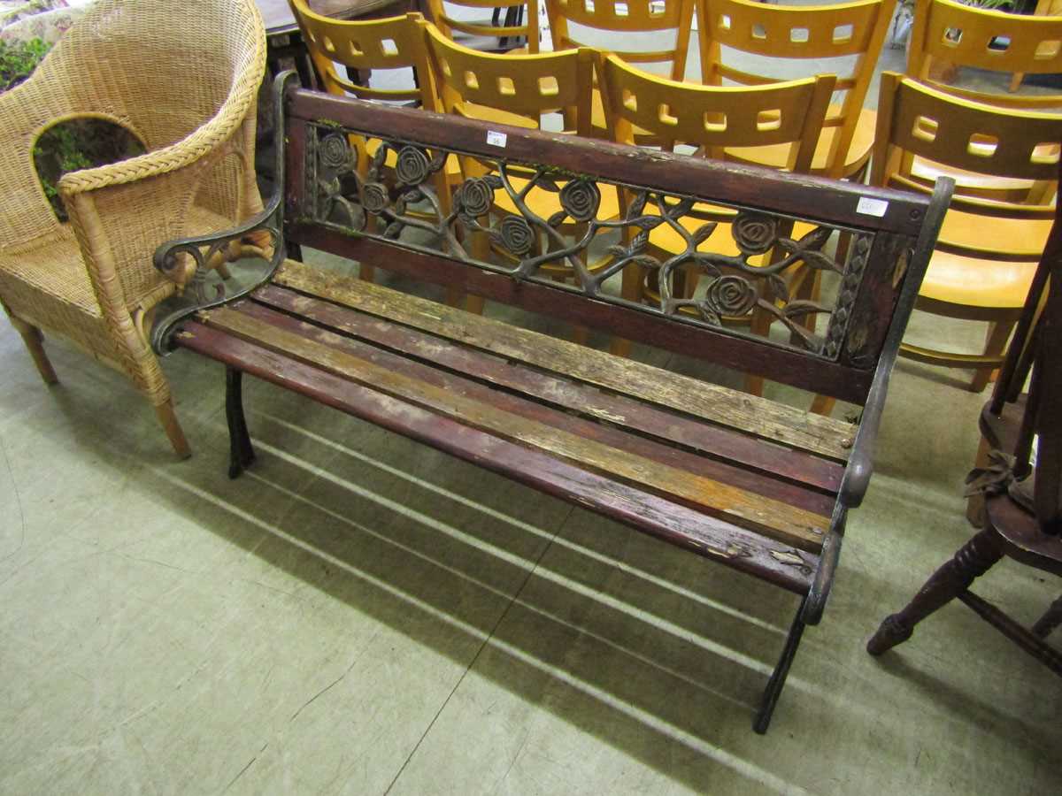 A weathered cast metal and wooden garden bench