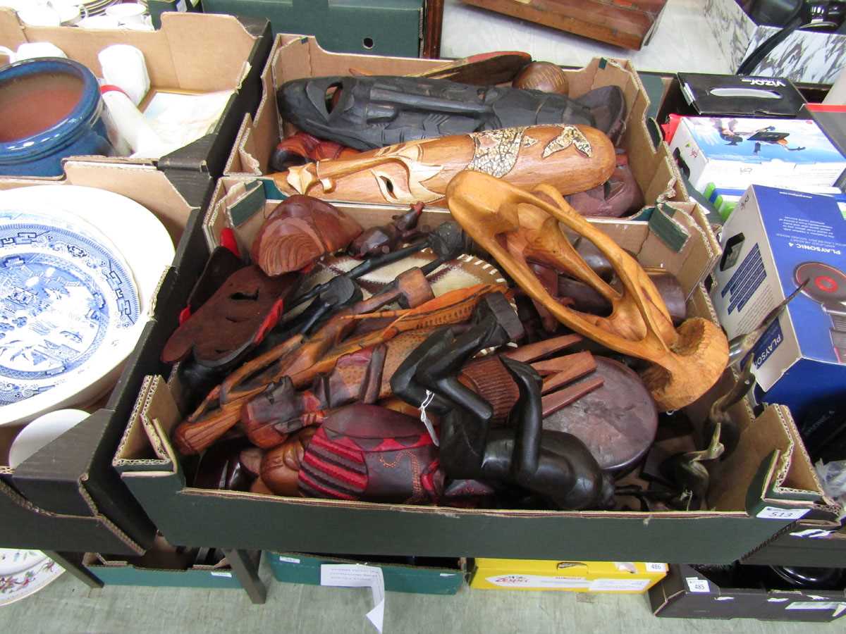 Two trays of reproduction carved wooden eastern masks and figures