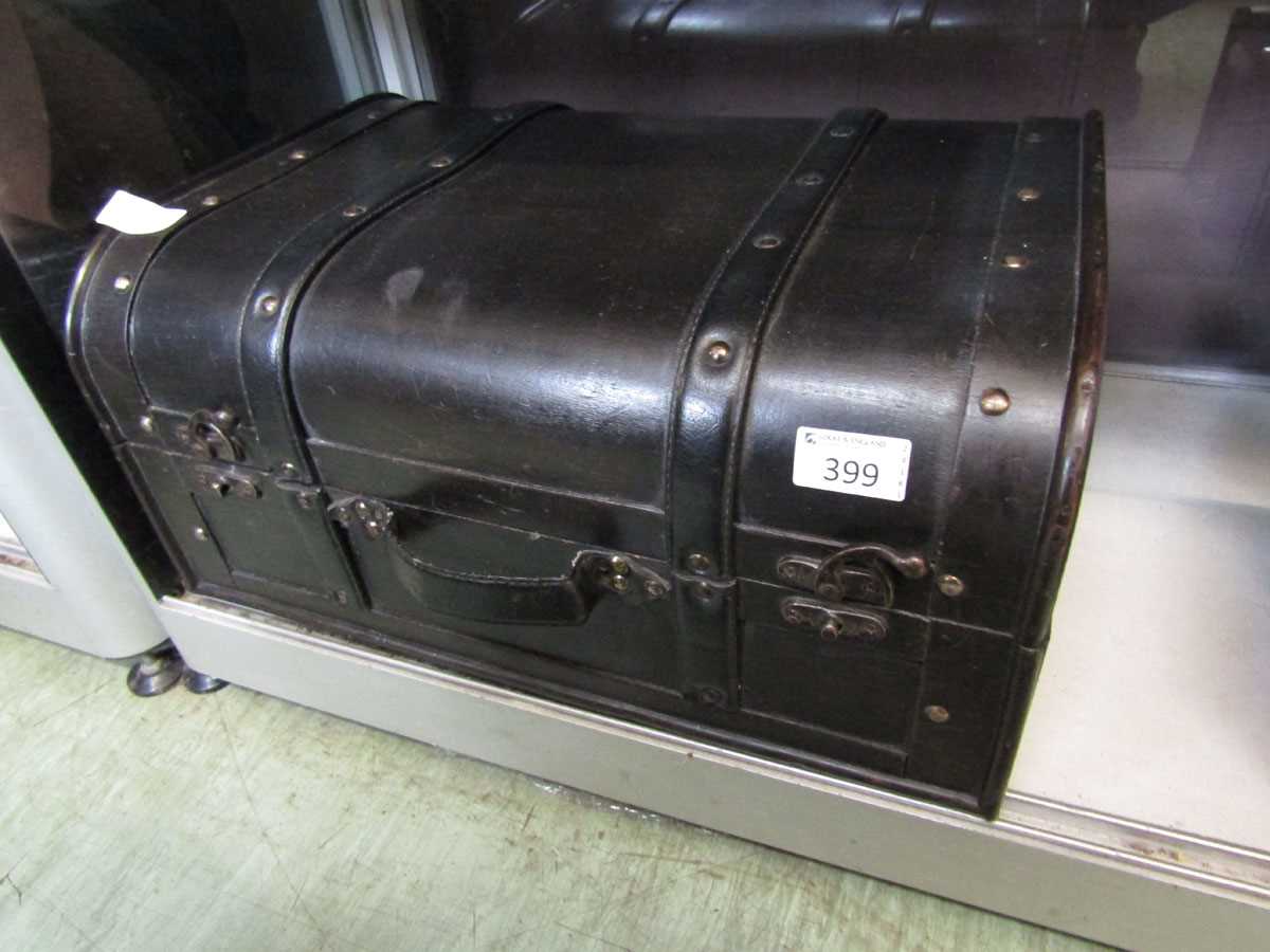 A black painted wooden box in the form of a treasure chest