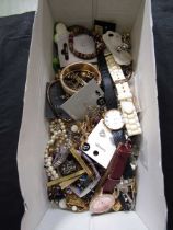 A shoebox containing a selection of costume jewellery and watches to include beads, bangles,