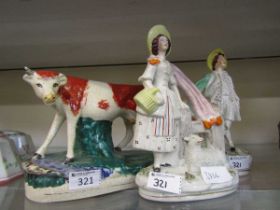 Two Staffordshire flat back figurines of lady and gentleman along with a Staffordshire figure of a