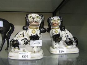 A pair of black and gilt design Staffordshire hearth dogs