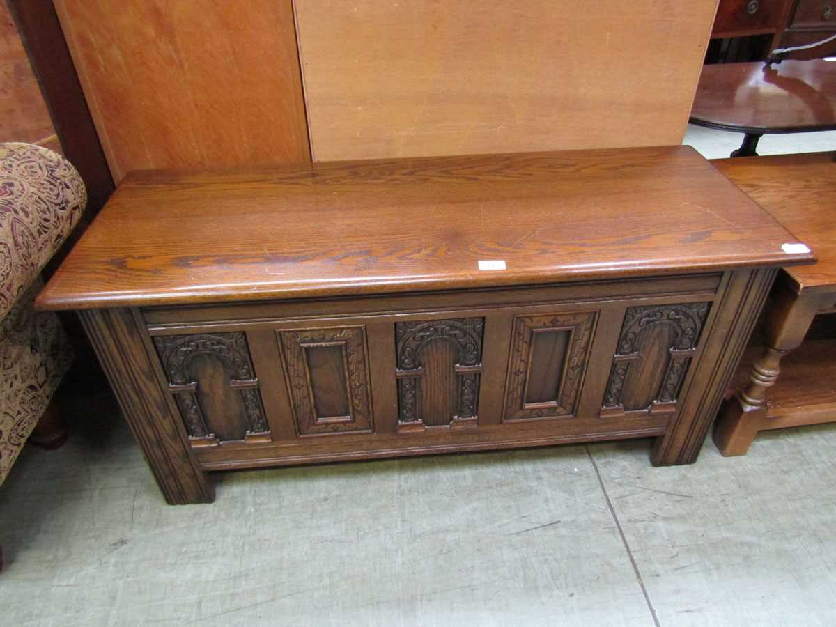 A mid-20th century oak linen box with carved front design