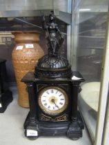 A Victorian style black painted cast metal mantel clock with figure of female warrior to top
