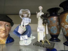 A Lladro ceramic figurine of young girl with flowers along with one other ceramic figurine of a lady