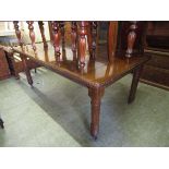 An Edwardian walnut wind out dining table with one centre leaf