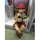 A moulded figurine of seated Pinocchio