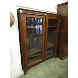 An early 20th century walnut glazed two door bookcase on cabriole supports