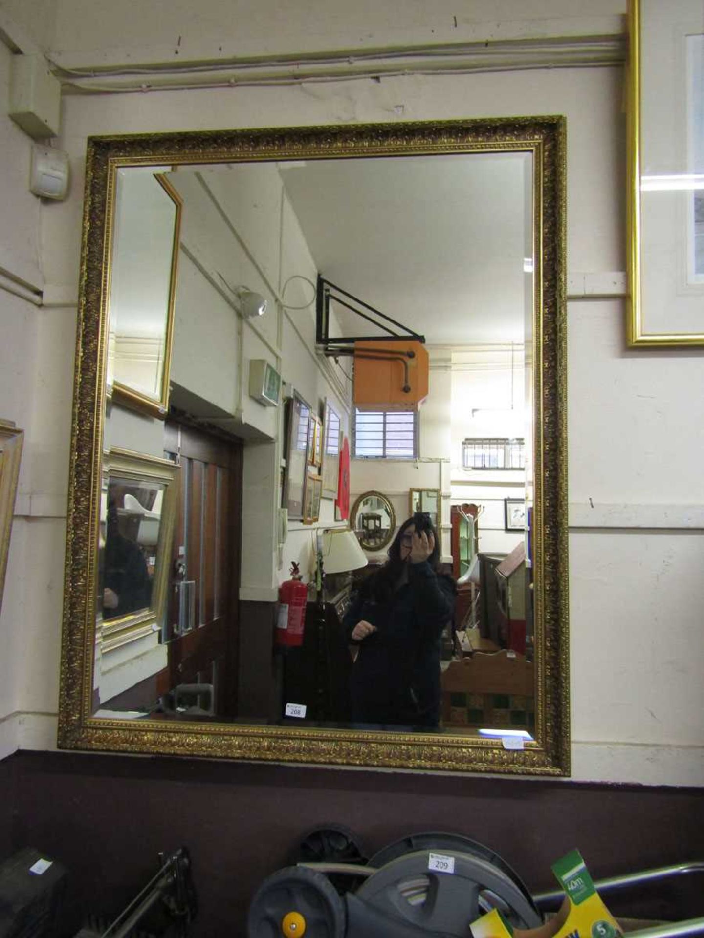 A large ornate gilt framed rectangular bevel glass wall mirror