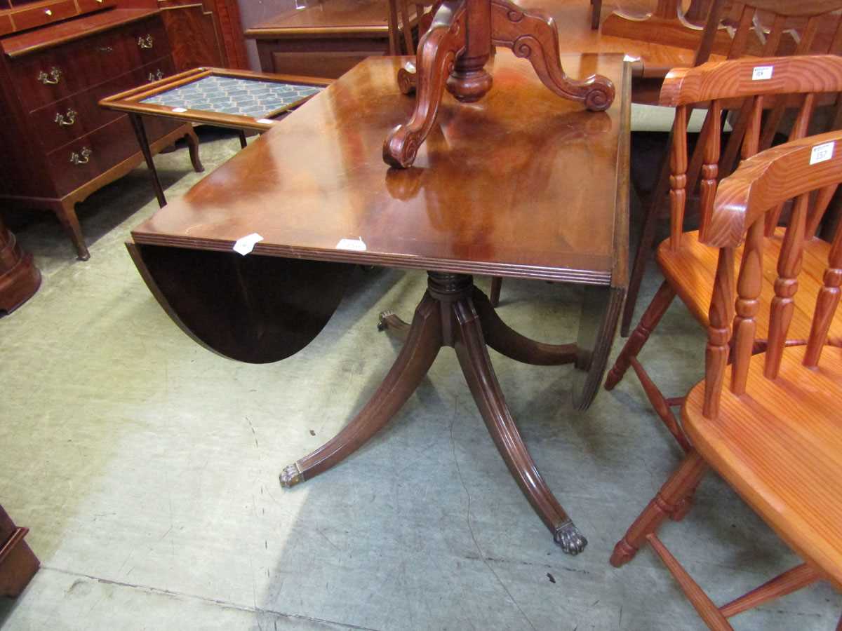 A reproduction mahogany pedestal drop leaf table