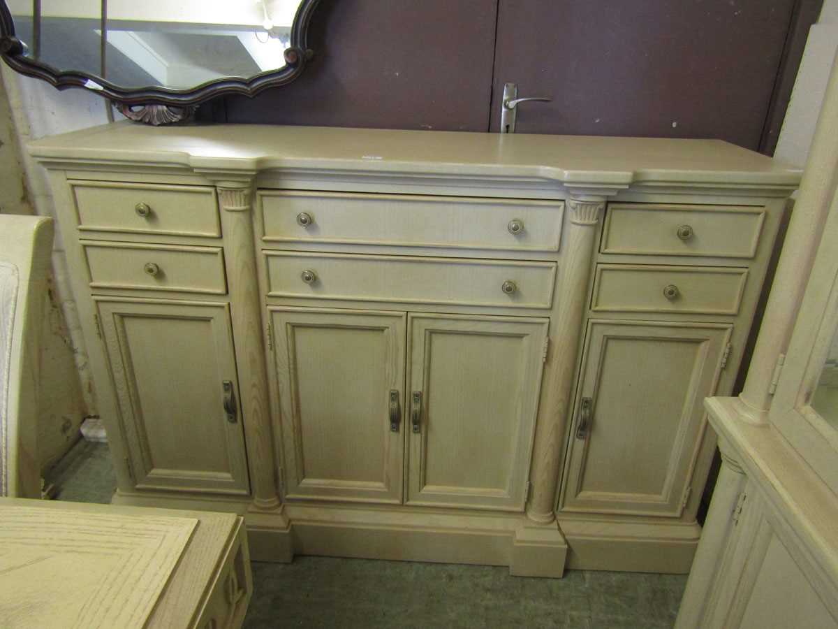 A modern limed oak effect continental sideboard having an assortment of six drawers over cupboard