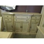 A modern limed oak effect continental sideboard having an assortment of six drawers over cupboard