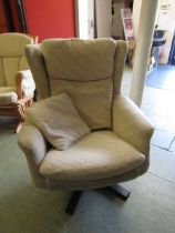 A mid-20th century swivel chair upholstered in a cream wool fabric