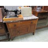 An early 20th century oak washstand having grey marble top, the base having a drawer above pot