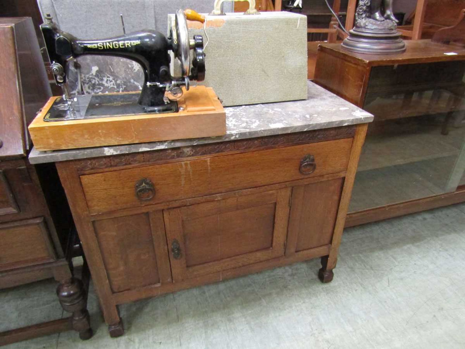 An early 20th century oak washstand having grey marble top, the base having a drawer above pot