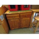 A small pine dresser base having two drawers above two cupboard doors