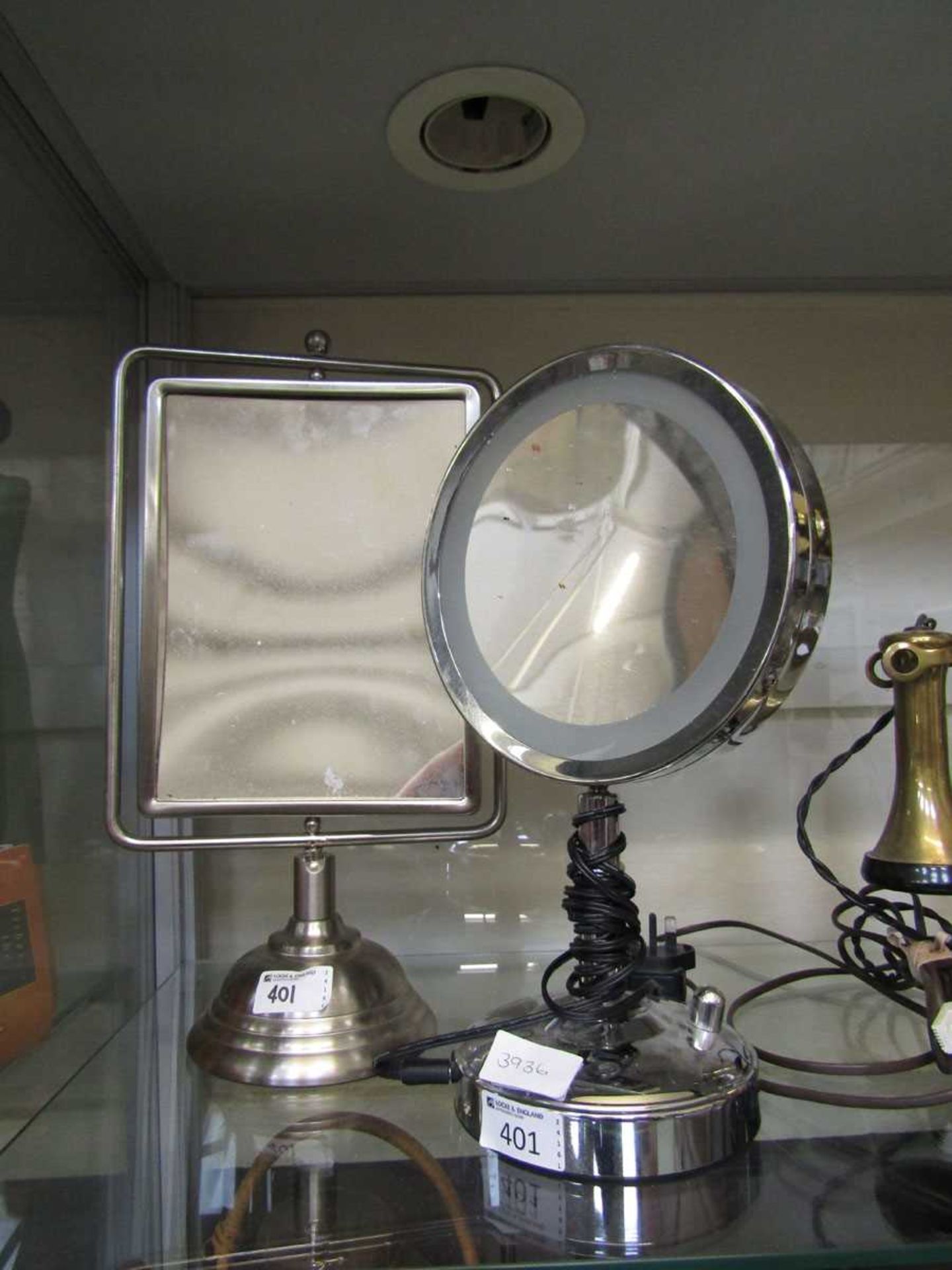 A stainless steel desktop swing mirror along with one other light-up desktop mirror