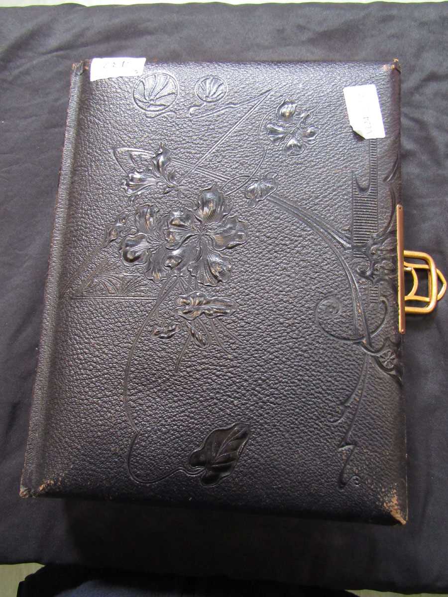 A Victorian black leather bound photo album with floral decoration