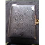 A Victorian black leather bound photo album with floral decoration