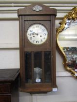 An early 20th century oak cased drop dial wall clock