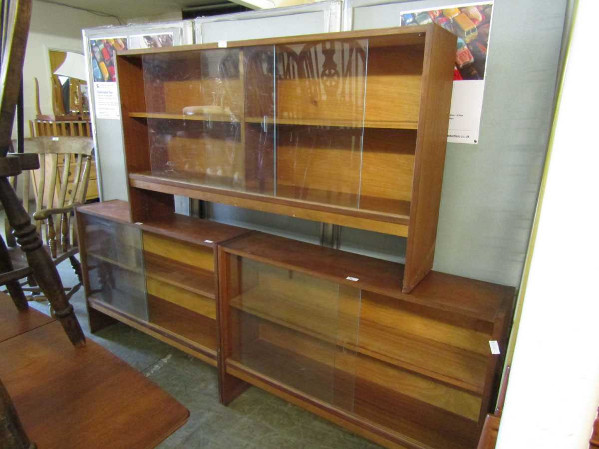 A pair of mid-20th century teak glazed sliding bookcases together with one similar