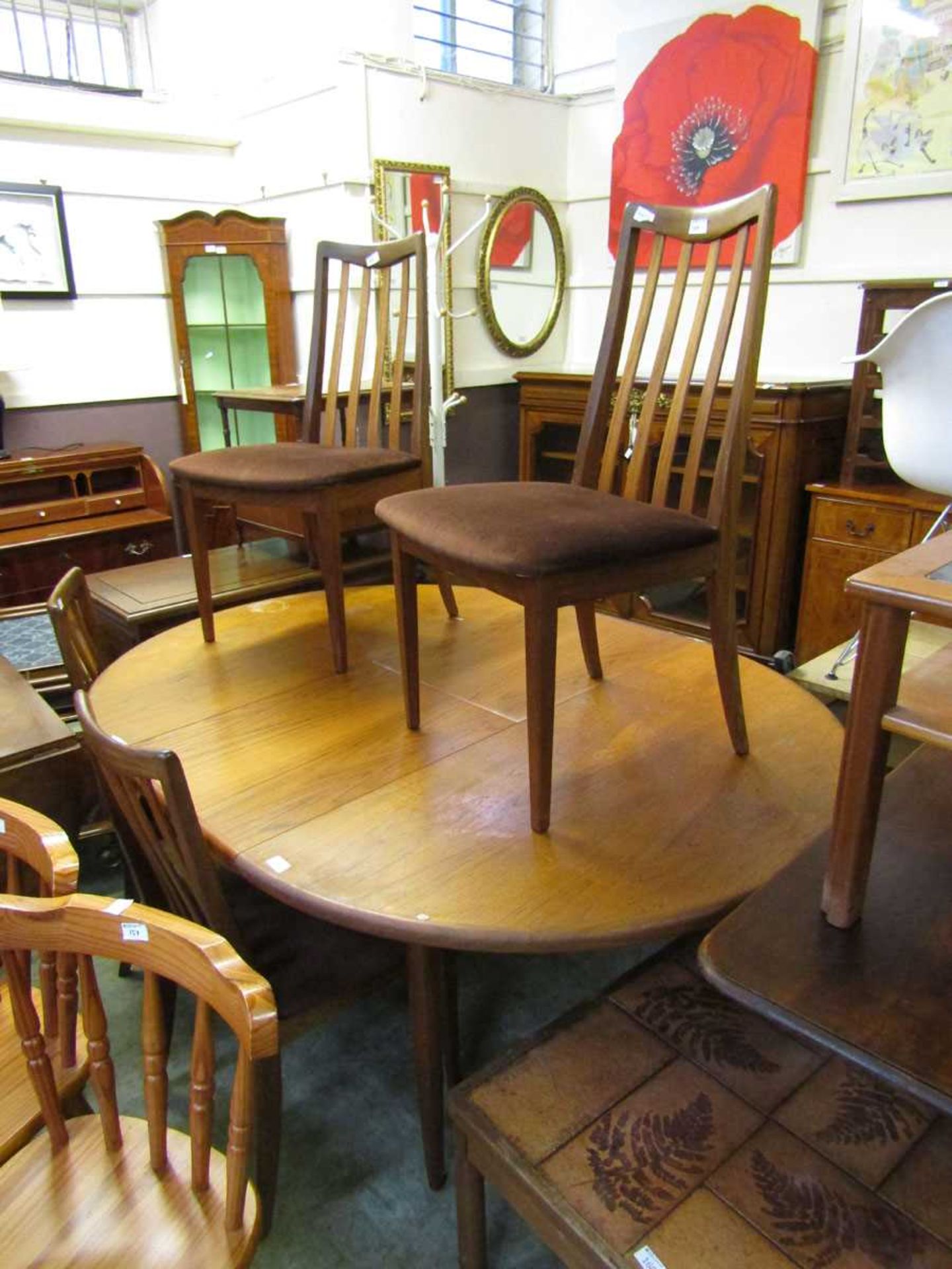 A mid-20th century teak extending dining table with a set of four matching chairs