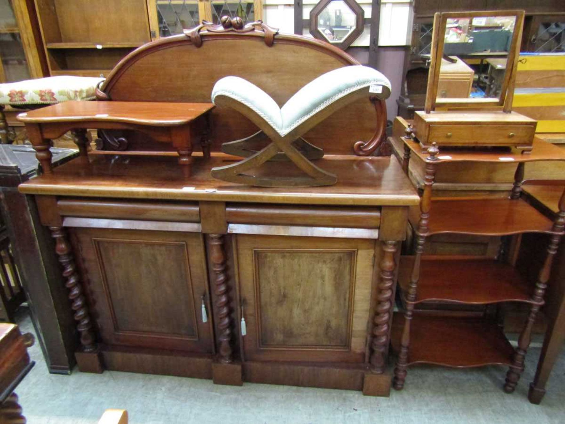 A Victorian mahogany chiffonier having raised back with fruit design, the base having two cushion