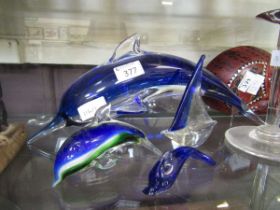 Three Murano style glass models of dolphins along with a similar glass model of a boat
