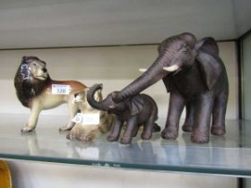Two carved wooden figures of elephants along with a Midwinter ceramic figurine of a tiger and a