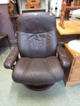 A brown leather reclining swivel chair