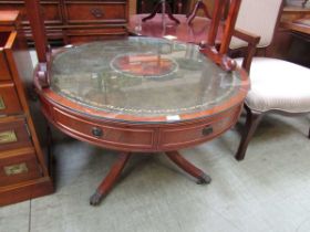 A reproduction mahogany drum table having a green tooled leather inset to top with glass top
