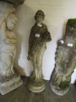 A weathered stoneware garden statue of young maiden