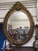 A reproduction ornate gilt framed substantial bevel glass wall mirror