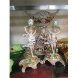 Two late 19th century figural candlesticks with floral encrustations, along with a similar