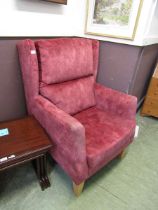 A salmon pink upholstered wing armchair