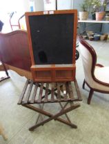 A folding slatted luggage stand together with a mid-20th century blackboard