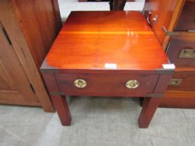 A cherry wood low level campaign style coffee table with single drawer