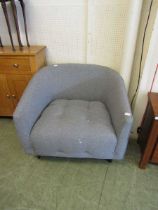 A modern grey fabric upholstered tub chair