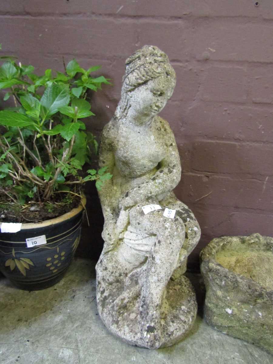 A weathered stoneware statue of young maiden